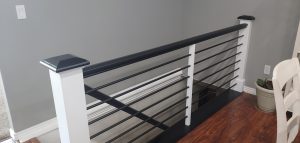 Black horizontal railing with white posts.
